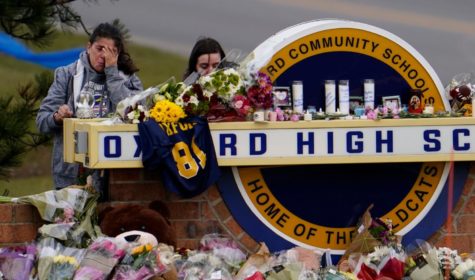 Youth and community members bringing flowers and praying at a makeshift memorial at Oxford High School on Dec. 2, 2021, after four students were shot dead and several injured. 
