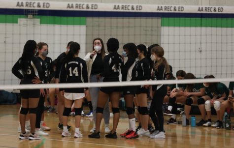 Coach of the Clague 7th and 8th grade girls volleyball team discussing strategies with team members during the match against Forsythe. 