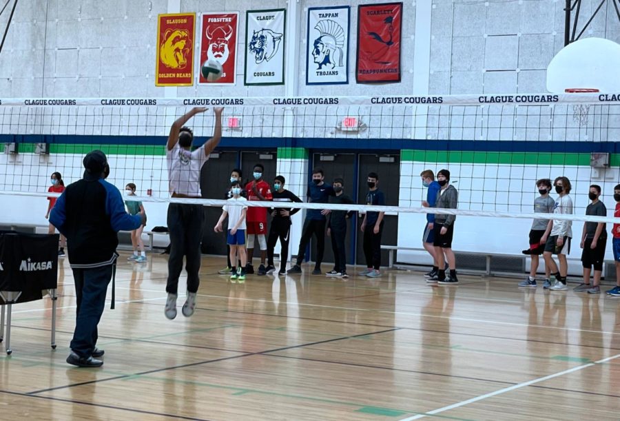 Clague 7th and 8th grade boys volleyball team running a drill during a practice session.