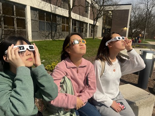 Eighth graders Alene Jamin, Amelia Bai and Caitlinn Cho outside of Clague’s main entrance. When the moon was in the sun’s path, the lights turned on outside of Clague Middle School because it got so dark.