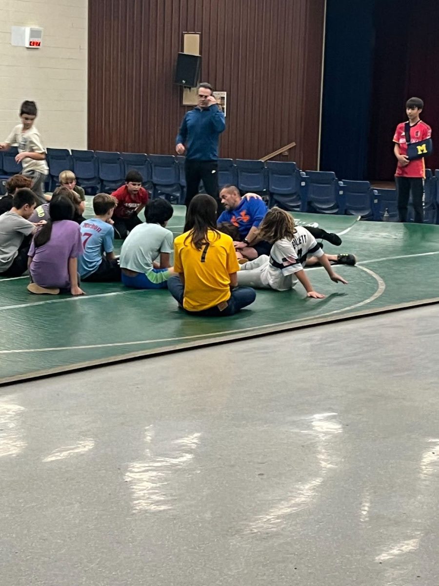 The wrestling team listens to their coach before practice starts.