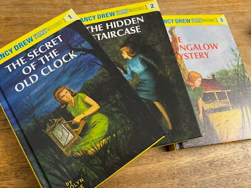 The first three books in the "Nancy Drew" series. Starting from left to right, the first book of the series is "The Secret of the Old Clock," the second book is "The Hidden Staircase," and the third book of the series is "The Bungalow Mystery."