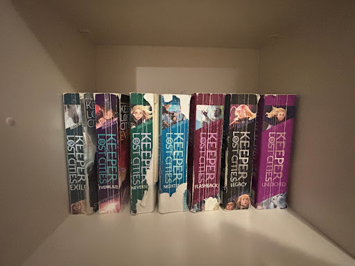 Book two, three, four, six, eight and 8.5 of the "Keeper of the Lost Cities" series by Sharon Messenger on the shelf.
