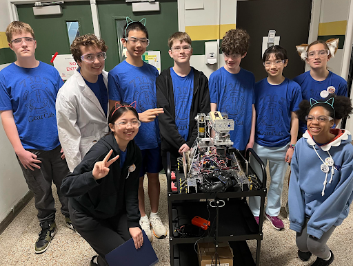 Team 7035 posing with their robot. (Left to right) Jacob Davidson (8), Leo Manolidis (8), Benjamin Wang (8), Noah Davidson (8), James Sandstedt-Fields (8), Kate Wang (6), Mia Manolidis (6), Ellie Wen (8) and Jaleya Grady (7). Not pictured: Lorelai Davey (8) and Jordan Bowman (7). Courtesy of Anouck Girard.