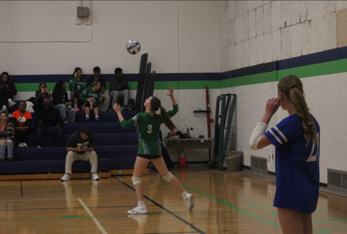 The Cougars go for the serve.