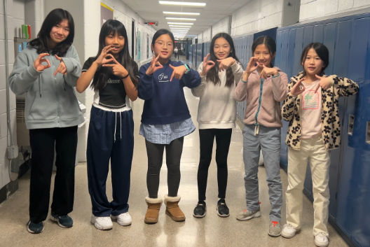 Katherine Wang, Elyse Kwon, Aeda Baang, Lea Park, Jamie Zuo, and Jacey Zuo (order from left to right) holding up six-seven with their hands.