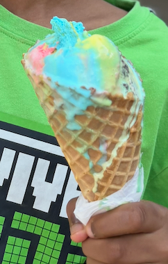 The Superman Scoop
A huge scoop of the Michigan Superman ice cream, known for its bright red, yellow, and blue swirls. It’s vanilla flavored, made of red pop, and blue moon.