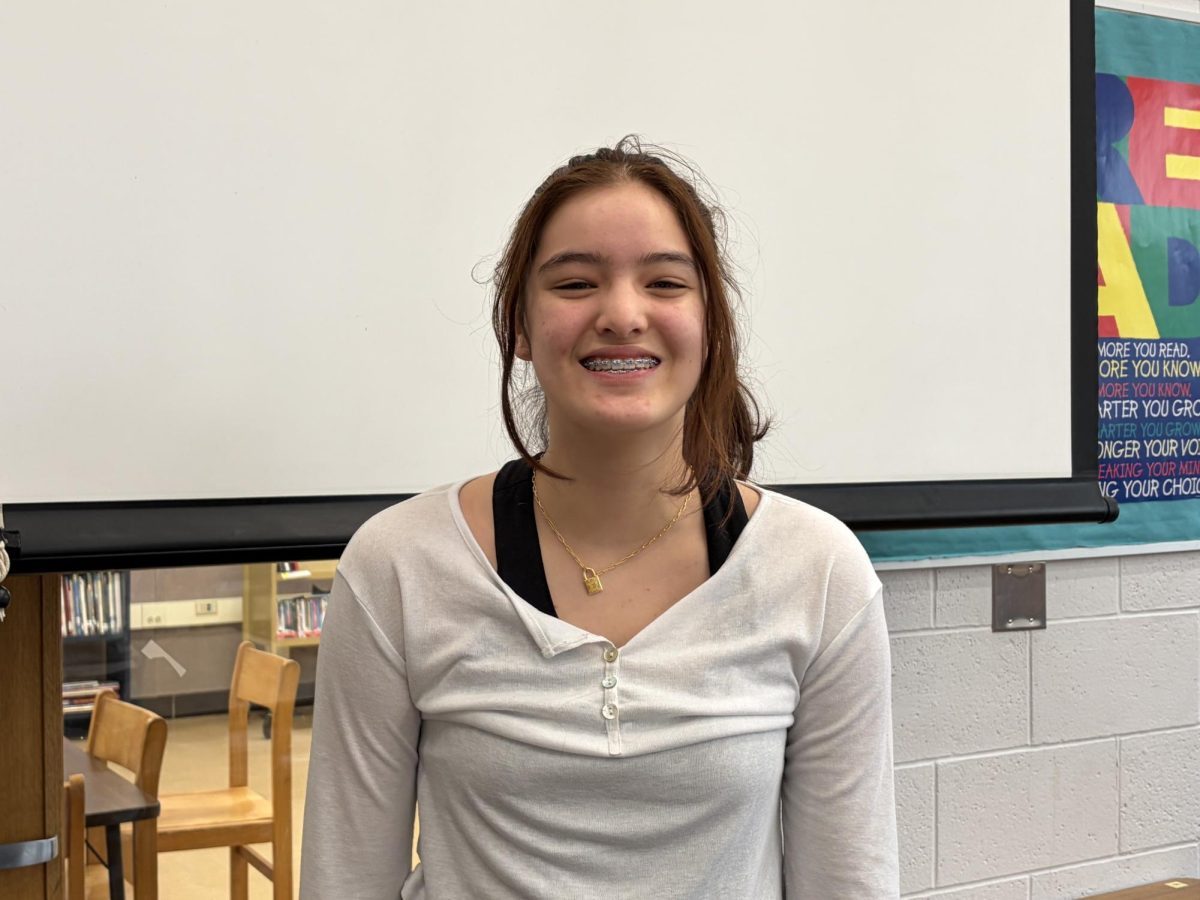 Photo of Lenaya Lee smiling in the library during 2nd hour. 