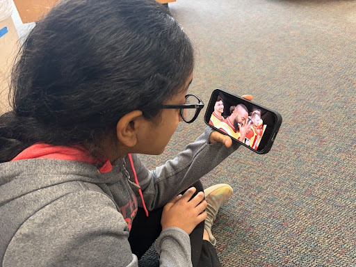 Seventh grader Sana Subbu Arumugam shows influencer Mr. Beast on her phone.
