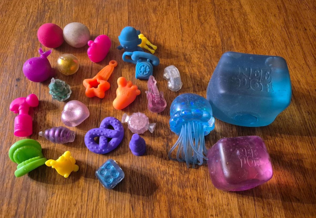 A photo of a blue NeeDoh Nice Cube, a purple NeeDoh Nice Cube, a NeeDoh jellyfish, and NeeDoh squishies from a NeeDoh advent calendar.
Courtesy of Annabelle Goebel